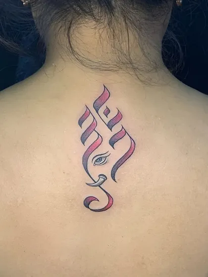 A stylized Ganesha tattoo on the back, created with calligraphic lines and a hint of color. This minimalist design is a modern tribute to the deity.