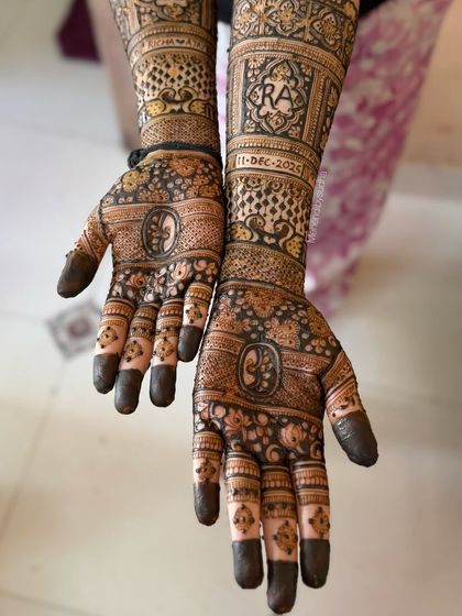 A top-down view of the engagement mehendi, showing the symmetry and balance between the personalized elements and the traditional patterns.