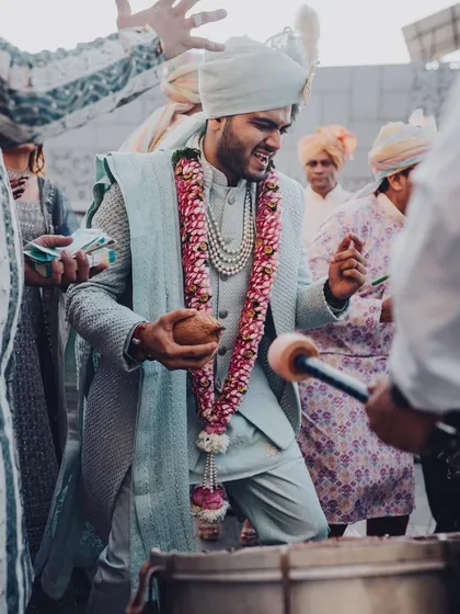 The groom can't contain his excitement during his baraat, dancing to the beat of the dhol. We love capturing this raw energy.
