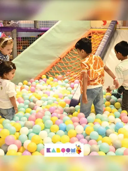 A mix of ages enjoying the ball pit together. It's a space where everyone can find their own way to have fun.