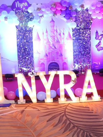 The birthday girl, Nyra, celebrating her first birthday on her princess castle-themed stage.