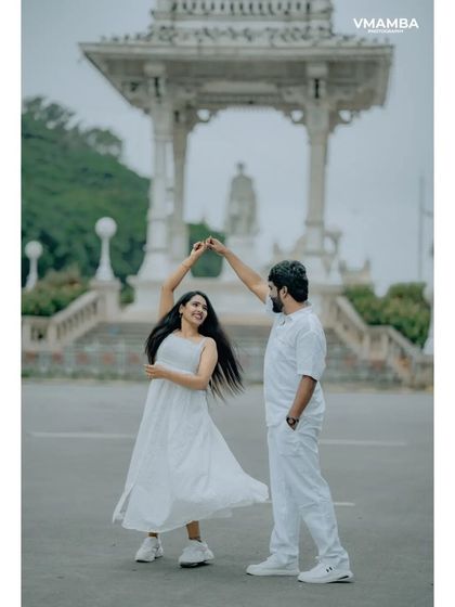 A fun and dynamic pre-wedding shot of a couple dancing in front of a monument. We capture your energy and joy in every photo.