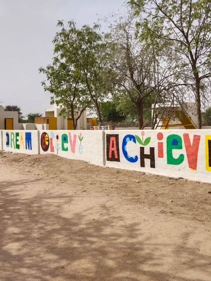 Another variation of the "Dream Believe Achieve" mural, with each letter designed in a unique, playful block style.
