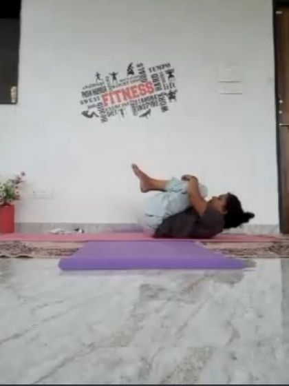 A student practicing Apanasana (Knees to Chest Pose) in an online session. This shows how our students can comfortably follow along from their own homes, receiving the full benefits of a guided class.