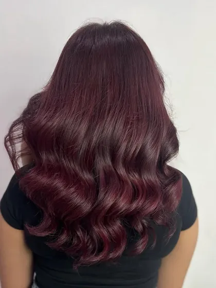 For those who love a bold statement, this deep burgundy global color is a showstopper. We finished the look with a layered cut and bouncy waves to add movement and make the rich color pop.