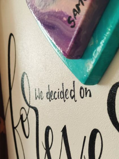 A detail shot of the "forever" sign, showing the hand-painted calligraphy and the layered, 3D heart element that makes this piece so special.