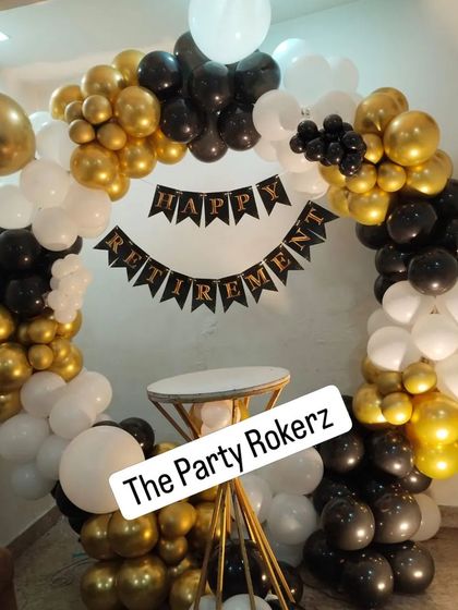 The complete retirement party photo booth, with a full balloon ring and a cake table, providing a festive spot to honor the retiree.