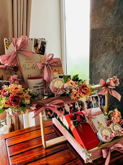This is one of my most cherished creations, a multi-tiered wedding gift for a best friend. It features personalized elements like a photo reel of shared memories, a custom mug, and curated gifts, all unified by a soft pink and floral theme to celebrate the bride-to-be.