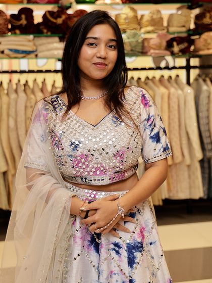 A closer view of the tie-dye mirror work lehenga. You can see the reflective details and the unique color pattern, making it a perfect outfit for a daytime event or sangeet.