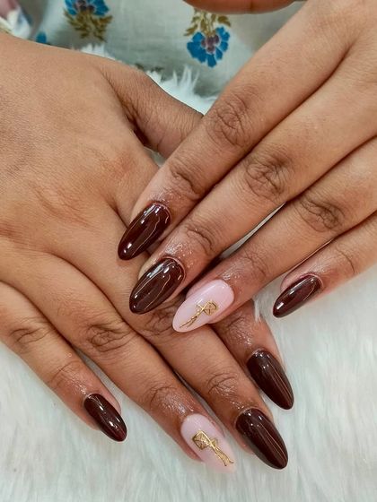 Still feeling the Makar Sankranti vibes with these festive nails. The set features a deep brown base with a light pink accent nail and a golden kite design.