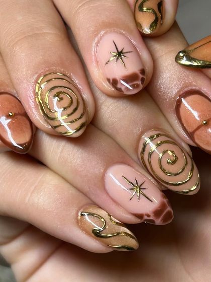 Another look at the artistic brown and gold nail set, showing how each nail has a unique but cohesive design.