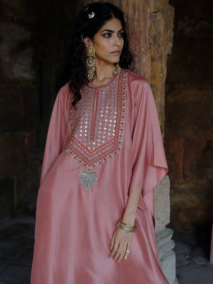 A closer look at the dusty rose kaftan, focusing on the intricate mirror work and bead detailing around the neckline.