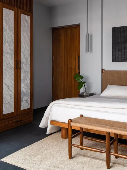 Wardrobe shutters in the master bedroom, featuring panels of marble inlaid within a solid wood frame. This is a design I created to elevate a functional item into a luxurious feature, blending stone and wood.