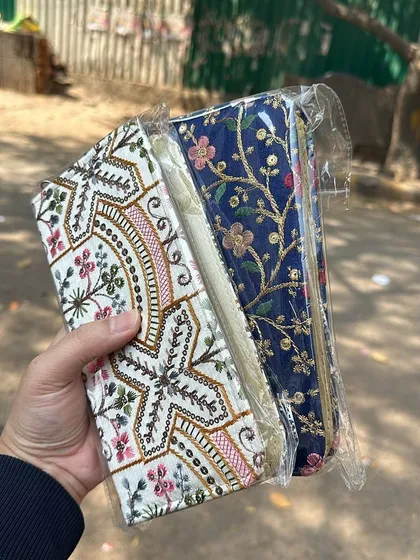 A pair of intricately embroidered clutches. The patterns are traditional yet timeless, making them a unique accessory for any event.