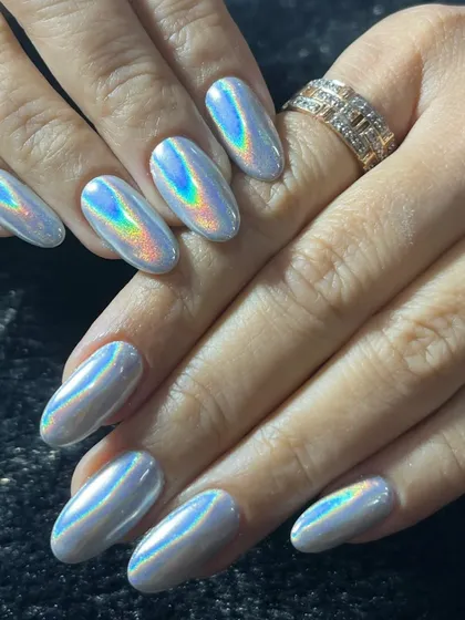 I love keeping up with the latest trends, and holographic chrome is a client favorite. These almond-shaped nail extensions have a smooth, mirror-like finish that catches the light and shifts through a rainbow of colors.
