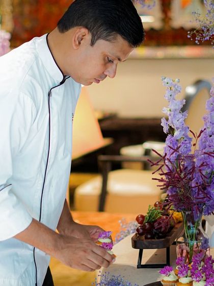 Our chef meticulously arranging cupcakes on a grazing table. Every element of our food display is thoughtfully placed to create a beautiful overall composition.