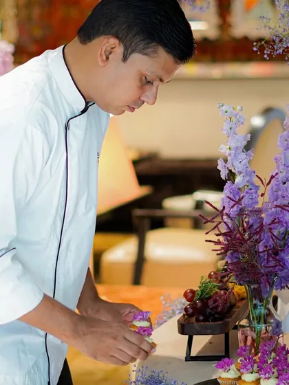 Our chef artfully arranging cupcakes on a grazing table. Every element is carefully placed to create a visually stunning and delicious display, combining savory bites with sweet treats.