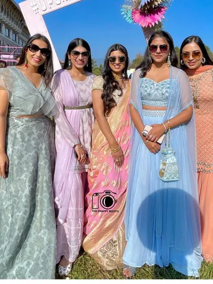 A group of elegantly dressed ladies enjoying the sunny weather and our photo booth at the #UpUnKiShaadi wedding.