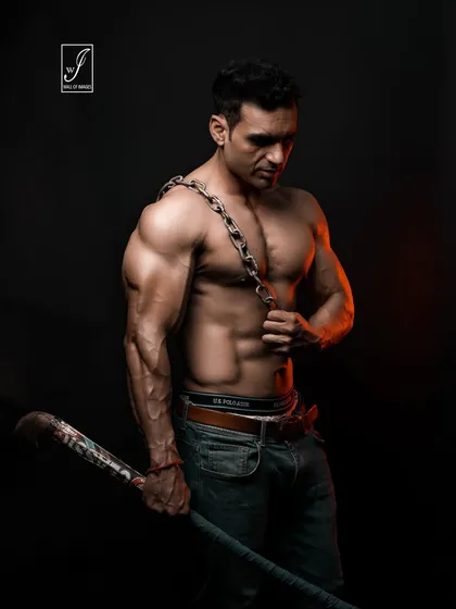 This shot is all about raw power. The use of heavy chains as a prop adds a gritty, visceral element, emphasizing the subject's strength and creating a dramatic, no-nonsense fitness portrait.