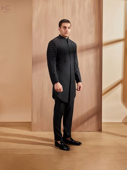 A full-length view of the pleated-sleeve achkan, showcasing its strong lines and contemporary feel. It’s a garment designed for making a memorable entrance.
