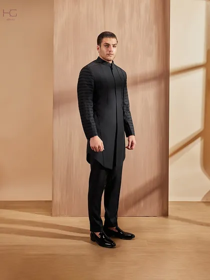 A full-length view of the pleated-sleeve achkan, showcasing its strong lines and contemporary feel. It’s a garment designed for making a memorable entrance.