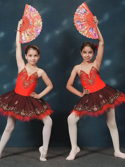 Dancers from our 'Don Quixote' performance. The use of fans as props adds a fiery, Spanish-inspired flair to the classic ballet choreography, showcasing both technique and personality.