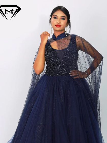 A close-up of the navy blue gown's beaded bodice and high-neck cape detail. The craftsmanship is designed to make you feel like royalty.