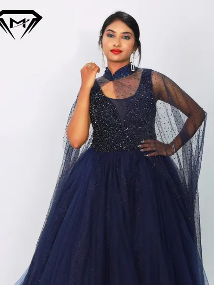 A close-up of the navy blue gown's beaded bodice and high-neck cape detail. The craftsmanship is designed to make you feel like royalty.