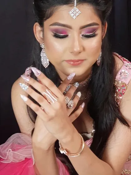 A beautiful shot of a model ready for her big day. Her nails are long and glamorous, featuring a mix of white, glitter, and crystal embellishments perfect for a bride.
