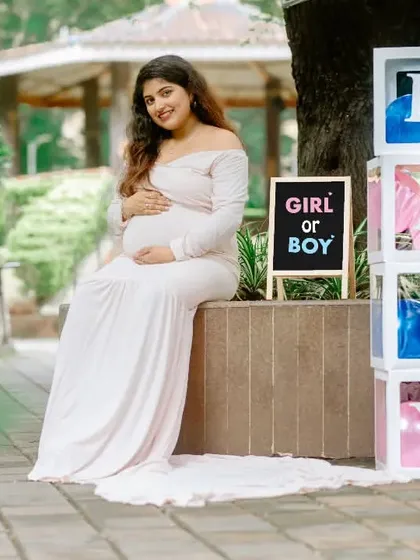 A beautiful solo portrait of the mother-to-be with 'Girl or Boy' and 'BABY' block props, capturing the anticipation of the gender reveal.