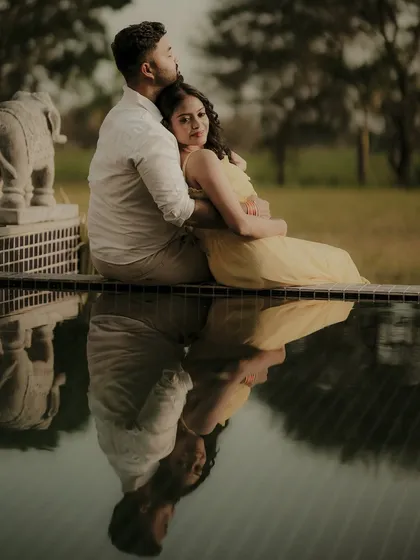 Using reflections is a beautiful way to add an artistic layer to a portrait. Here, the couple's embrace is mirrored in the still water, creating a perfectly composed and tranquil pre-wedding photograph.