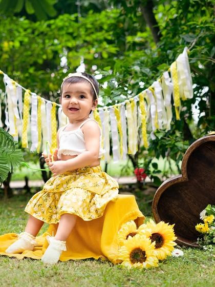 A sunny first birthday in a field of sunflowers. This outdoor setup is perfect for a nature-loving family, creating bright and cheerful portraits.