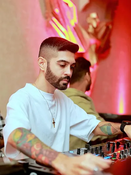 A clear, close-up shot of me focused on the mixer. This highlights my technical craft and concentration while I'm blending tracks and curating the sound for the night.