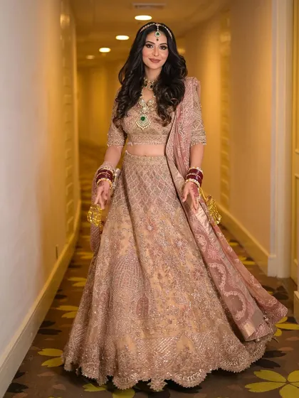 A full view of this regal and glamorous look. The soft makeup balances the heavily embellished lehenga, creating a look of timeless charm.