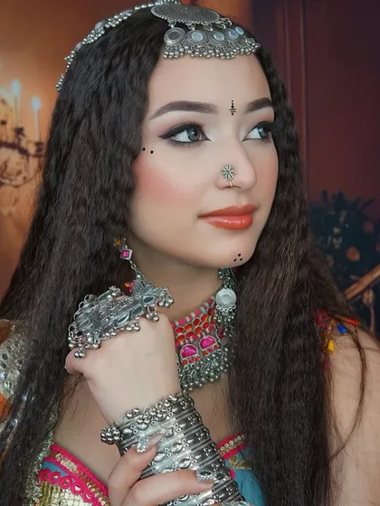 Another angle of the festive Navratri look, highlighting the flawless base makeup and the way the silver accessories complement the colorful outfit.