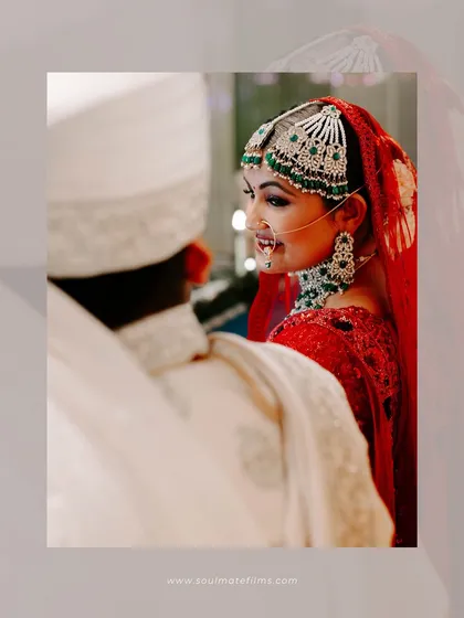 A beautiful over-the-shoulder shot of the bride looking at her groom. Her smile is full of love and adoration. It’s a classic, romantic moment.