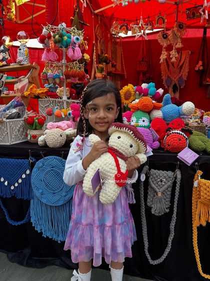 Our amigurumi toys are loved by everyone, from small kids to adults. This little girl is happily hugging one of our large plushies at our exhibition stall. All our toys are soft, handcrafted, and washable.