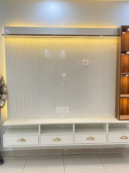 Presenting a finished TV cabinet with a large white back panel, fluted side details, and a lit-up wooden display shelf.