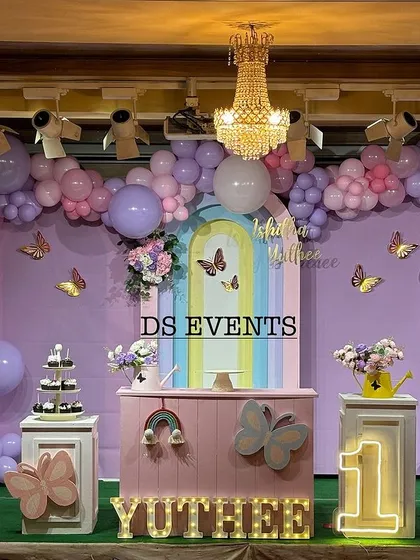 This is a full-stage butterfly theme I designed for a first birthday. It features a large pastel balloon garland, custom-painted backdrops, light-up marquee numbers, and themed props like the giant pink butterfly wings for a perfect photo opportunity.