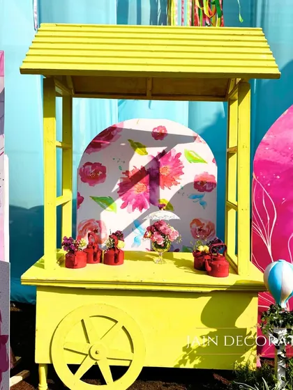 A bright yellow cart serves as a fun and colorful prop for a carnival-themed party. It's these playful details that bring a theme to life.