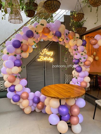 The mix of purple, peach, and rose gold balloons creates a soft and trendy look for this birthday photo booth.