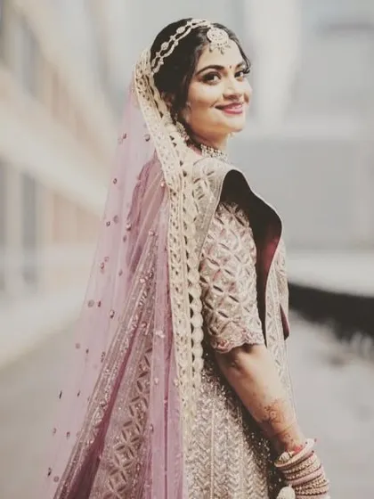 The bride looking back with a happy smile. Her complete look, from the soft makeup to the elegant hair, comes together beautifully.