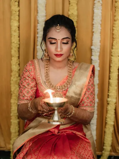For Dr. Pooja's bangle ceremony, we went for a classic and elegant look. The makeup features a defined eye and a bold red lip, perfectly matching her beautiful silk saree and traditional gold jewellery.