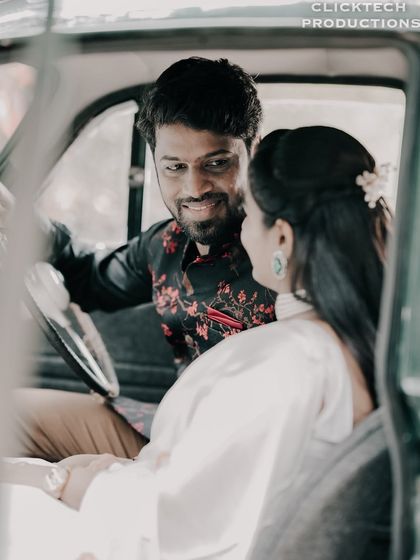 An intimate, through-the-window shot of a couple inside a vintage car, creating a cinematic and personal feel.
