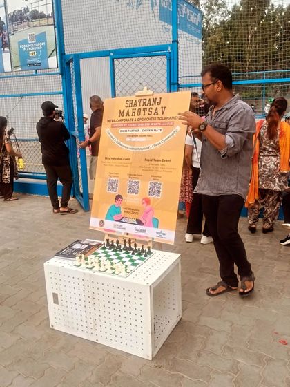 Our event coordinator holds up the poster for the 'Shatranj Mahotsav' tournament, ready to welcome players and provide details for the day's competition.