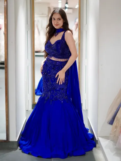 This is for my brides who want to make a statement. A modern fish-cut lehenga in a stunning royal blue, designed to highlight your curves. The intricate beadwork and dramatic silhouette are perfect for a glamorous cocktail night or sangeet.