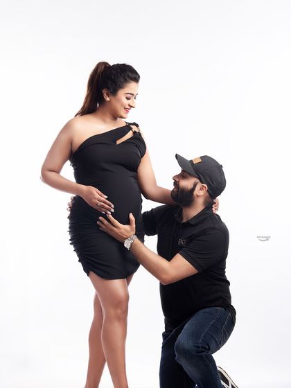 A sweet and adoring pose with the dad-to-be kneeling to embrace the baby bump. This is a classic and heartwarming shot that beautifully captures a partner's love and excitement.