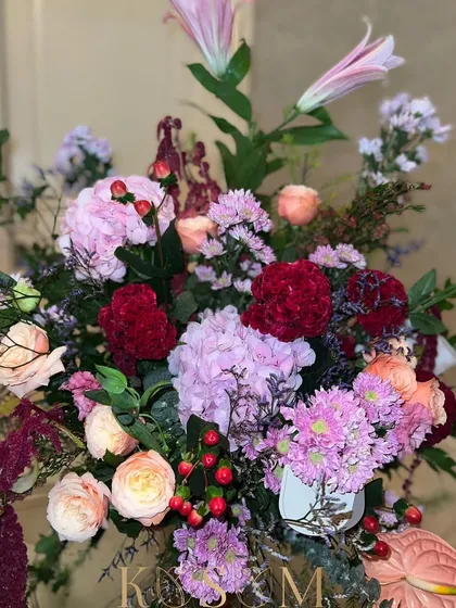 Iron reds and cozy peaches signal a move to a wintry colour palette. This arrangement feels like a fireplace and dinners by candlelight, with hypericum berries, lilies, and anthuriums.