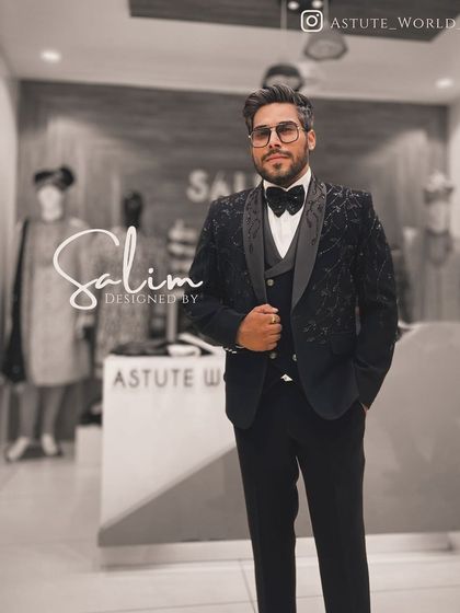 A client wearing a black three-piece tuxedo with subtle floral embroidery on the jacket. The matching waistcoat and trousers create a cohesive and polished look.