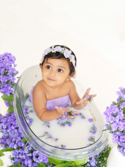 Playing with lavender flowers in her milk bath. This candid shot shows the curiosity and gentle play that happens during our floral tub sessions.